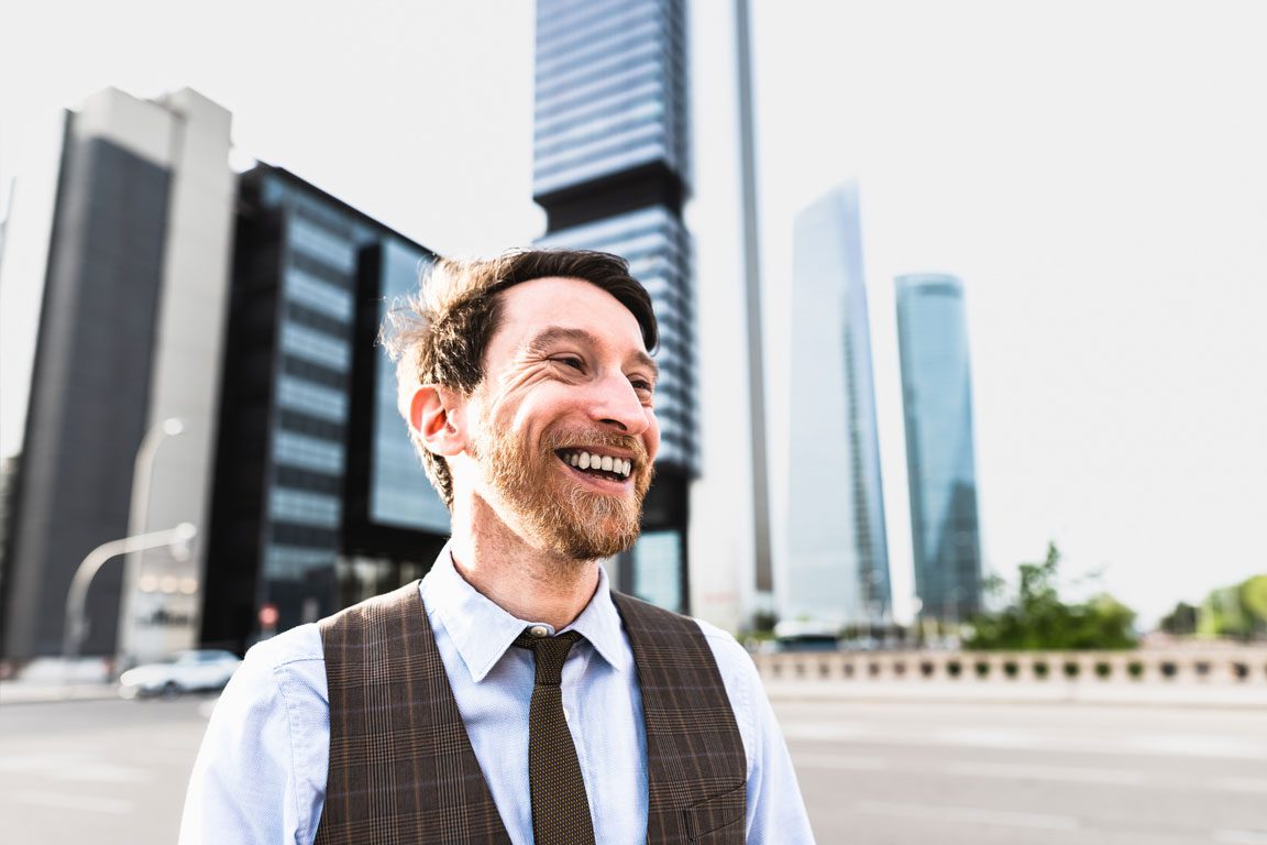 smiling businessman in a city outdoors