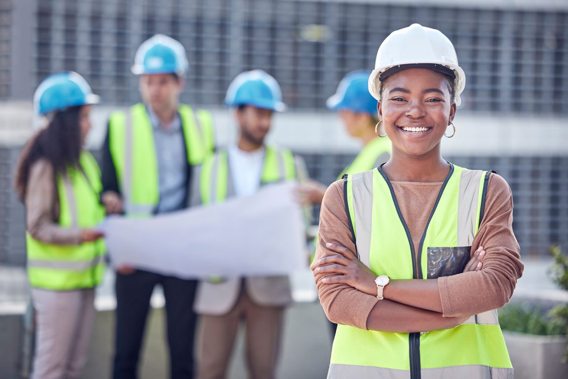 smiling African American female construction worker in front of co-workers